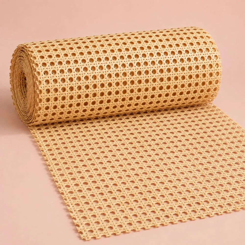 Roll of natural open weave cane webbing partly unrolled on a pale pink paper backdrop