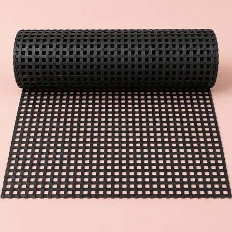 Roll of black plastic PE square weave cane webbing partly unrolled, showing the small square holes