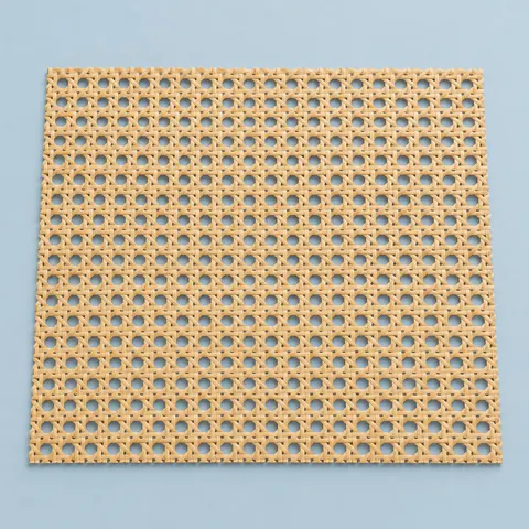 Flat rectangular sheet of open weave natural cane webbing with straight cut edges on a dusty blue backdrop