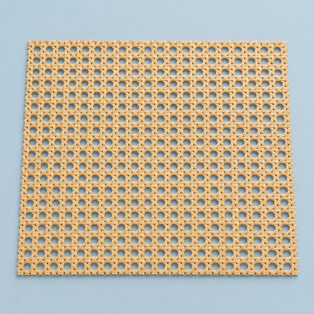 Lámina rectangular de rejilla de ratán de tejido abierto con bordes rectos cortados, sobre fondo azul grisáceo