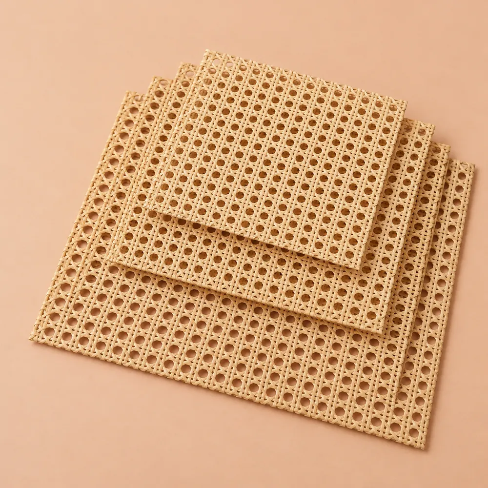 Offset stack of four open weave cane webbing sheets in graduated sizes, smallest on top, on a warm peach backdrop
