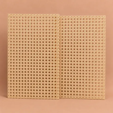Two matching open weave cane webbing sheets leaning upright side by side on a terracotta backdrop