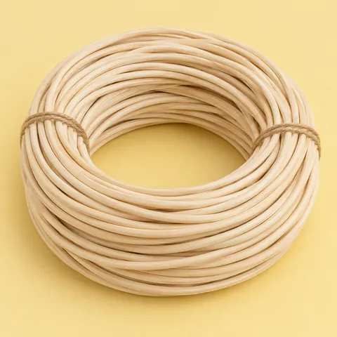 Large coil of natural reed spline loosely tied with two twists of twine on a butter yellow backdrop