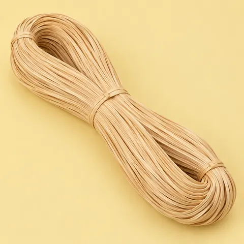 Large looped hank of glossy honey-blond strand chair cane tied in three places, on a butter yellow backdrop