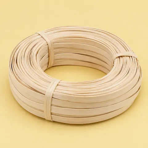 Coil of matte, pale cream flat reed strips about 1/2 in wide, tied, on a butter yellow backdrop