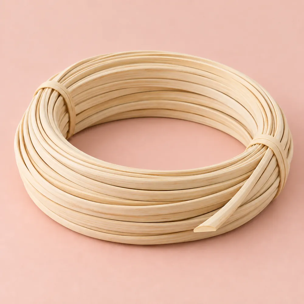 Coil of matte, pale cream flat oval reed, flat on one side and rounded on the other, on a soft pink backdrop