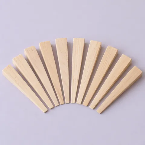 Ten smooth light hardwood caning wedges with thin tapered edges arranged in a fan on a pale lavender backdrop